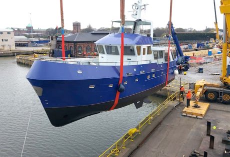 Ocean-going boat takes to the skies with crane lift launch